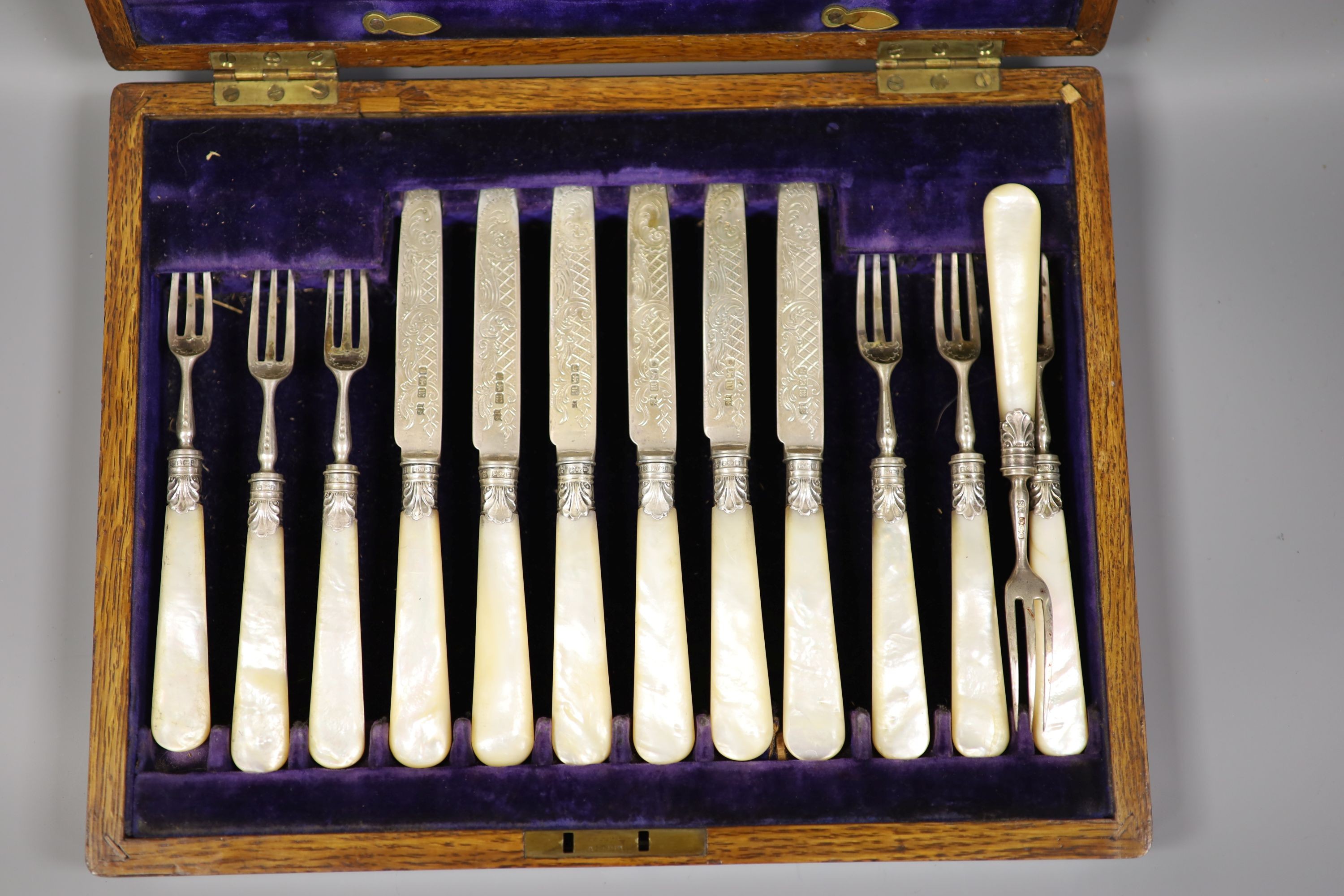 An Edwardian cased set of twelve pairs of mother of pearl handled silver dessert eaters, John Sanderson, Sheffield, 1904.